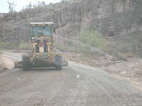 27-grader_spreading_gravel_with_a_wash_on_the_right_side_of_the_road