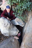 45-Eric_and_Brett_squeezing_through_rabbit_hole_to_descend_through_chock_stone_obstacles